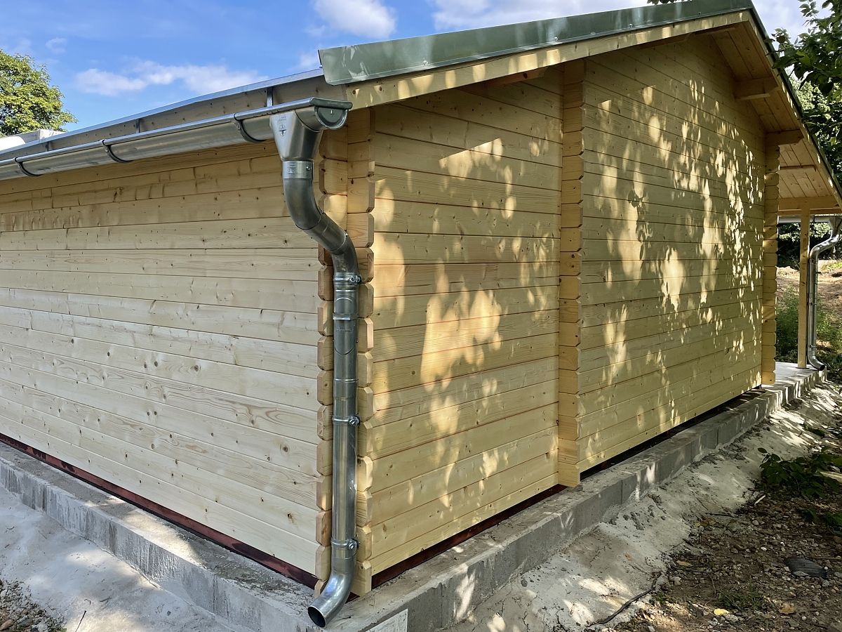 Camping EKO DD 440x300_PR - Zahradní chatka Camping s dvoukřídlými dveřmi a bočním přístřeškem. Okapy a svody pozink. Navíc okenice.